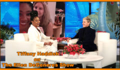 Tiffany haddish and ellen degeneres smiling and conversing on the set of the ellen degeneres show, decorated with festive elements.