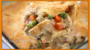 A close-up view of a serving of chicken pot pie with vegetables, with the watermark "hollywood.tv" across the bottom.