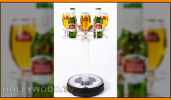 A rotating display stand holding three bottles of stella artois beer and accompanying glasses, highlighted with a blurred background.