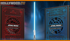 Two "star wars" themed playing card decks beside a glowing lightsaber, with a stormy sky in the background and "hollywood.tv" branding at the top.