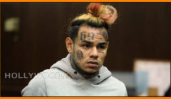 Man with colorful hair and facial tattoos wearing a gray hoodie in a courtroom, with "hollywood.tv" in the bottom right corner.